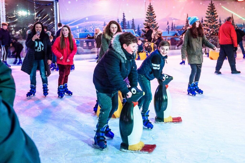 Families enjoying ice skating at a festive rink in Bognor Regis, highlighting fun things to do in Bognor Regis during the winter season.