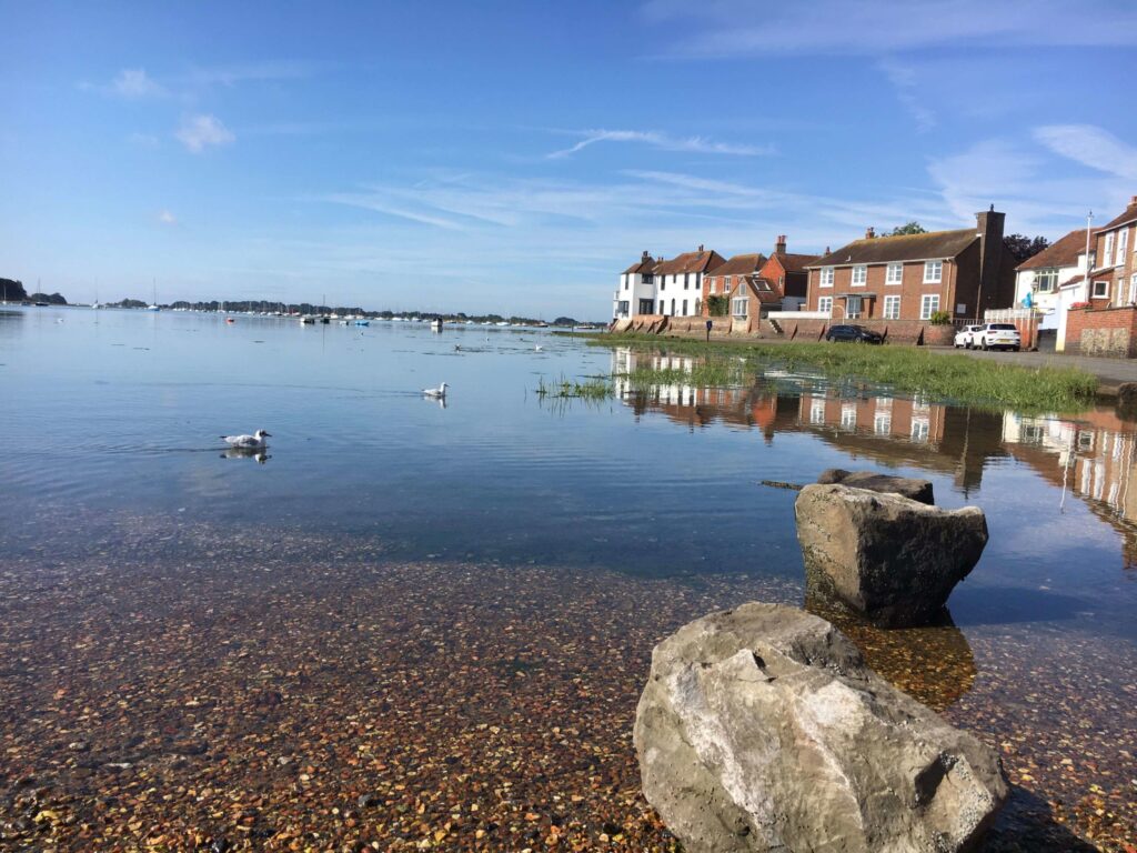 Scenic view of Bosham Harbour with boats and Chichester Harbour in the background, highlighting the best things to do in Bosham.