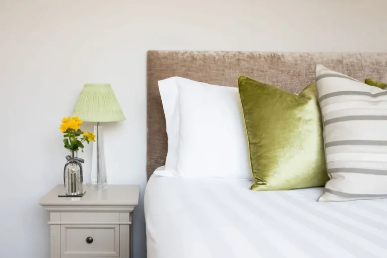 Cosy and well-decorated bedroom in a holiday home in Chichester, featuring plush bedding, stylish cushions, and elegant lighting for a comfortable stay.